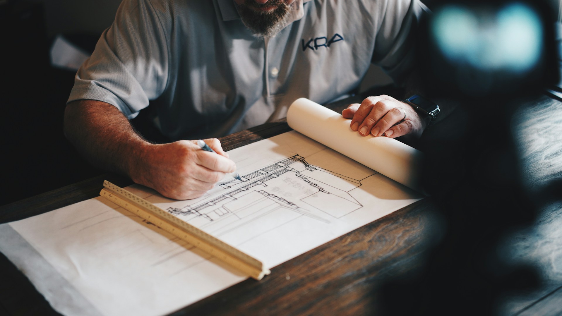 man drawing blueprints